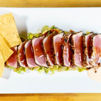 Ahi Tuna on a bed of lettuce, served with chips.