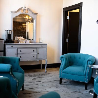 Bridal Suite interior with teal armchairs, a vanity, and a clock.