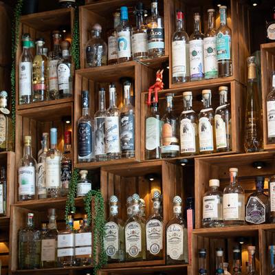 Wooden shelves filled with various liquor bottles.