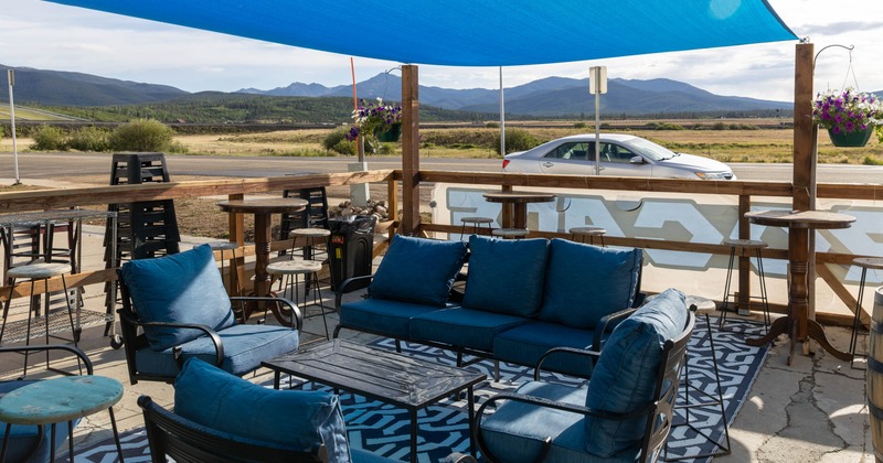 Exterior, covered seating area, low seating armchairs with table, high seating