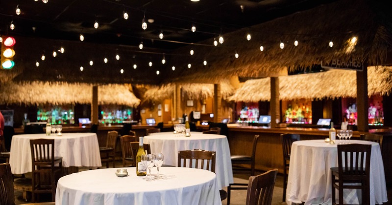 Interior, skirted table with wine, bars in the background
