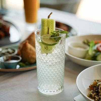 Cucumber lime drink served with various dishes.