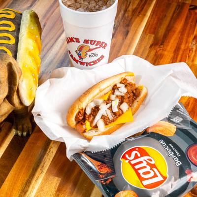 Chili Dog with onions served with a soda and a bag of chips.