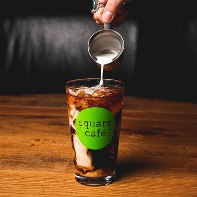 Iced coffee glass, pouring milk.