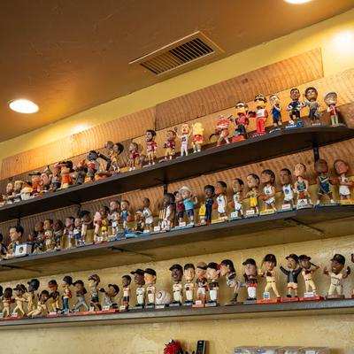 Collection of bobblehead dolls on display shelves.