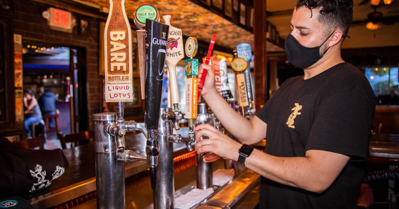 Staff member pouring beer