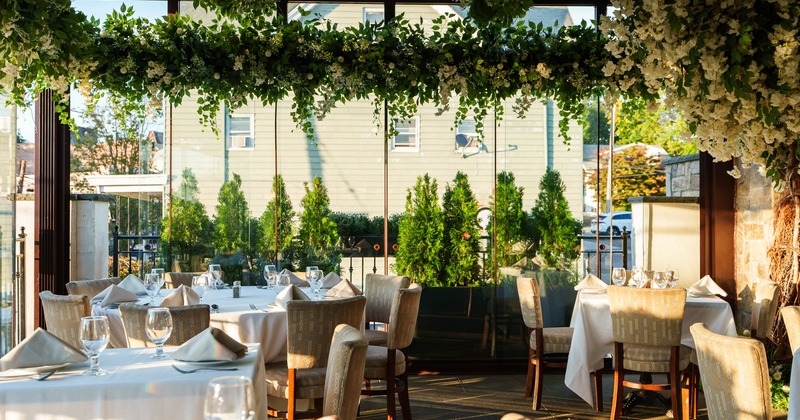 Interior decorated with plants, set tables ready for guests