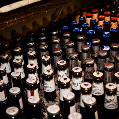 Assorted beer bottles in a cooler with ice.