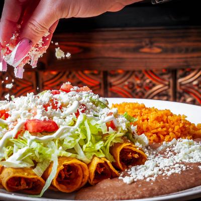 Flutas with sides being topped with crumbled cheese.