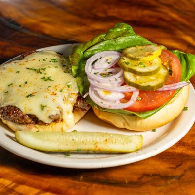 Cheeseburger with lettuce, tomato, onion, and pickles.
