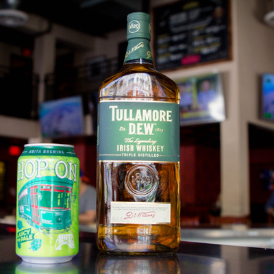 A bottle of Irish Whiskey and a can of Hop On pale ale photo.