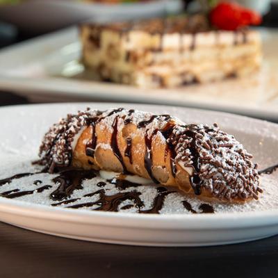 Cannoli, with chocolate drizzle and sprinkles.