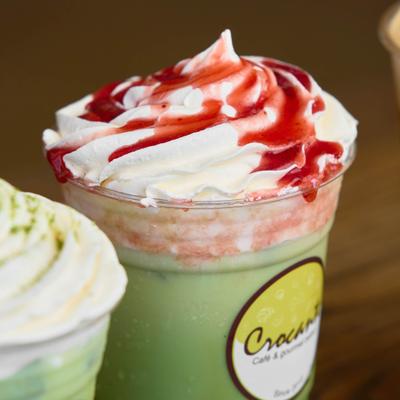 Matcha Latte with whipped cream and strawberry syrup.