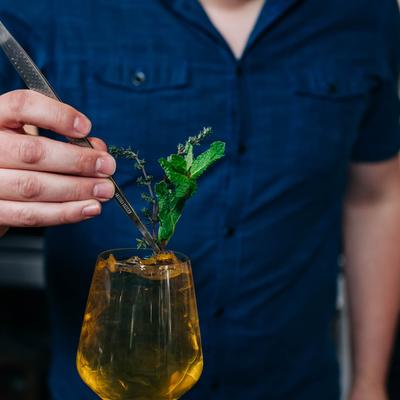 A person preparing a cocktail.