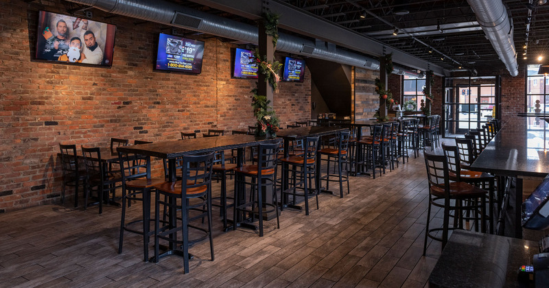 Interior, tables by the wall and TVs hanging on it