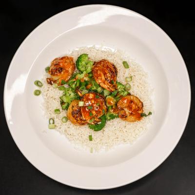 Shrimp served over rice with vegetables.
