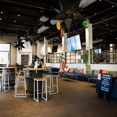 Interior space, seating  with barrel tables, stools, couches and coffee tables