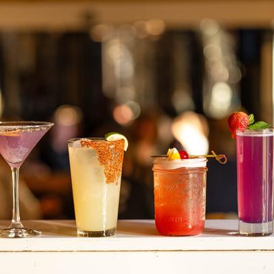 Four colorful cocktails on a counter.