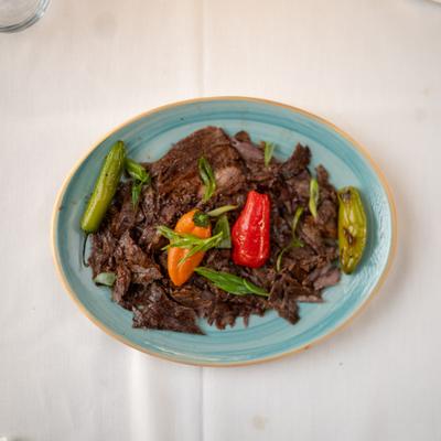 Shredded slow-cooked beef served with colorful roasted peppers.