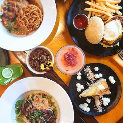 A variety of dishes and drinks on a table, top down view.