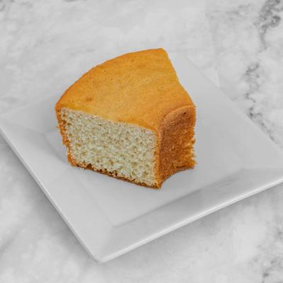 Slice of cardamom sponge cake served on a plate.