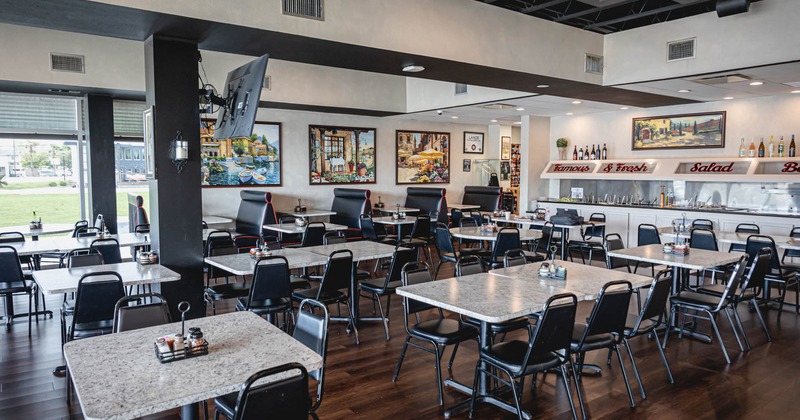 Interior, dining area, tables for four and six, seating booths with tables in the back, buffet bar