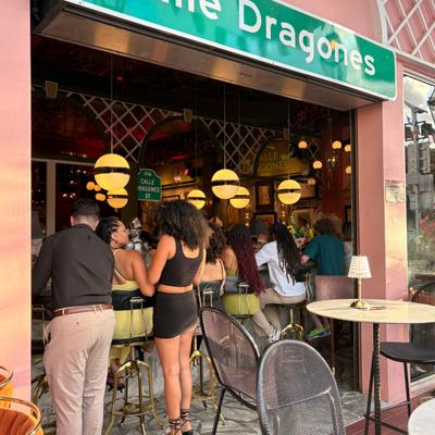 View from outside, people at the bar enjoying happy hour.