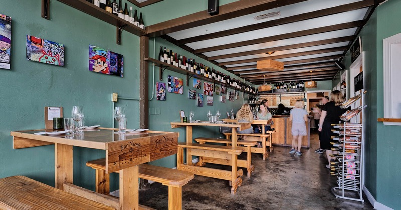 Interior, lined up tables with tableware, guests in front of the order counter