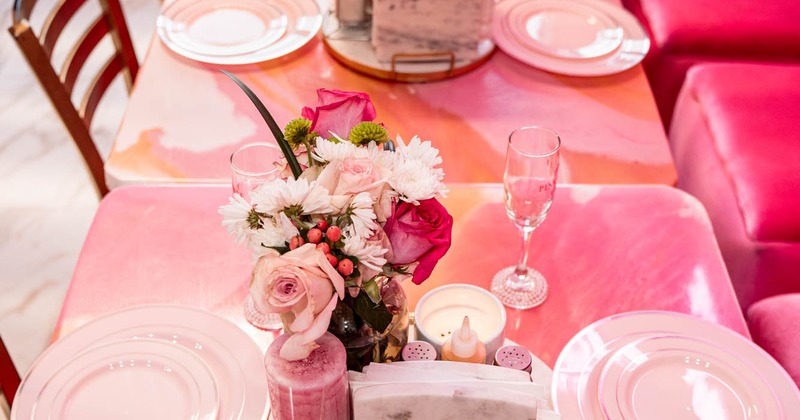 Dining table, with plates, glasses, and floral arrangements