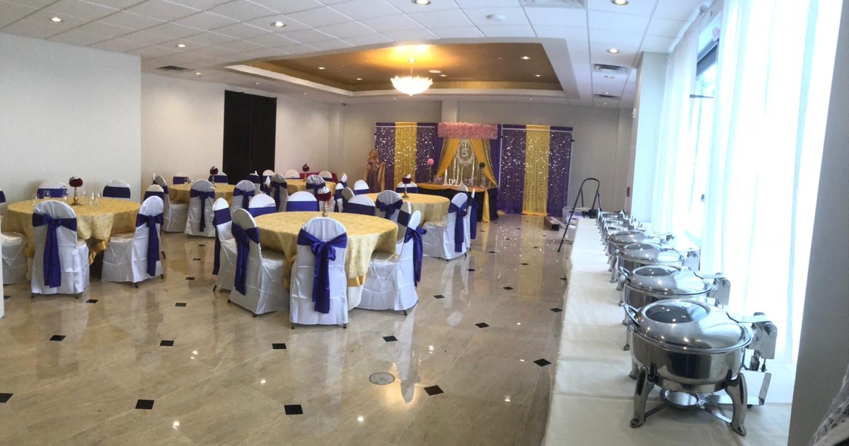A decorated banquet hall set up for a special event, featuring a buffet line and formal seating