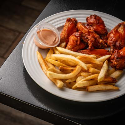 Saucy wings served with fires and a dipping sauce.