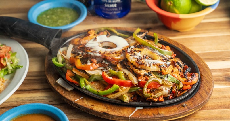 Hawaiian Fajitas with steak, chicken and pineapple topped with queso