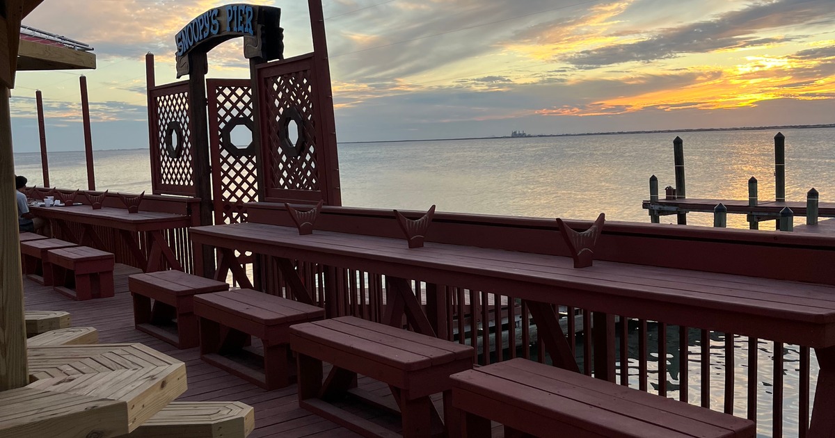 A serene wooden deck with benches at the Snoopy's, offering a picturesque view of the water