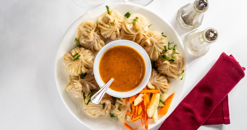 Steamed momo dumplings served with veggies and house chutney