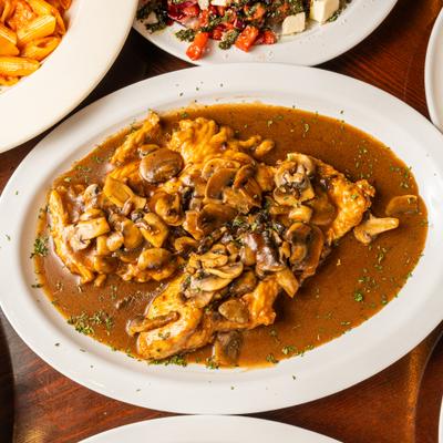 Chicken marsala topped with mushrooms and sauce.