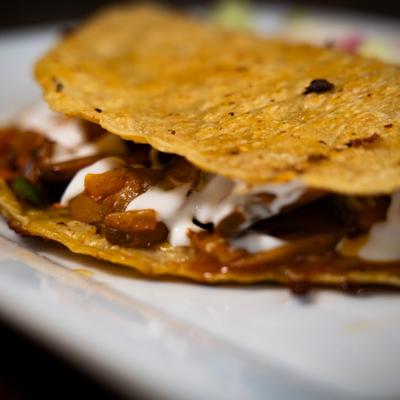 Quesadilla filled with vegetables and crema.