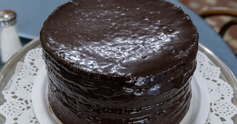 Whole Smith Island cake on a white plate, resting on a doily
