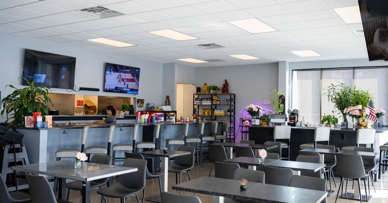 Interior, dining area, tables with chairs, bar with stools, checkout counter