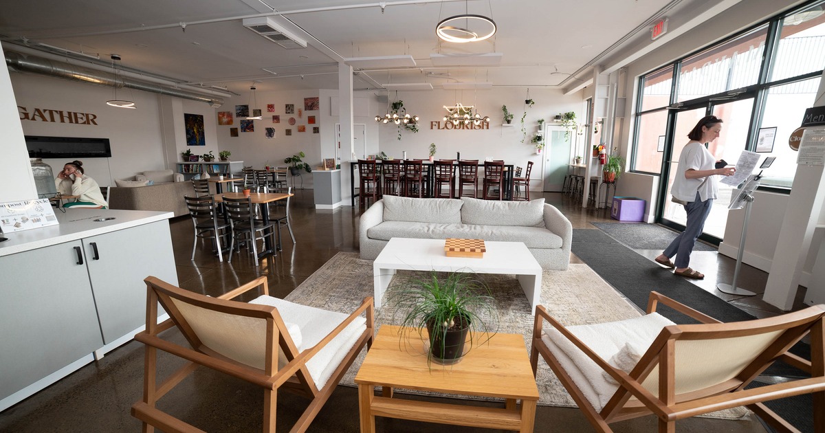 Lounge area with white sofa and armchairs and table seating in the background