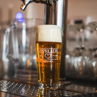 A glass of draft beer on a drip tray.