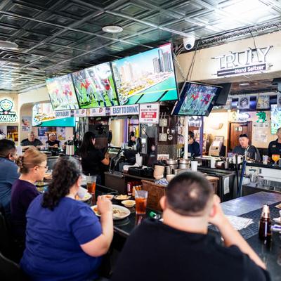 Busy bar, wall-mounted TVs.