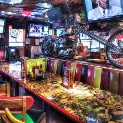 A vibrant diner with a motorcycle displayed above colorful, retro-style booth seating