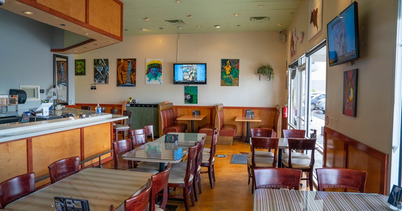 Interior, order counter, dining tables and restaurant booths, artwork and TVs on walls