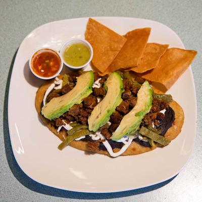 Huarache topped with refried beans, carne asada, avocado, served with chips and salsa.