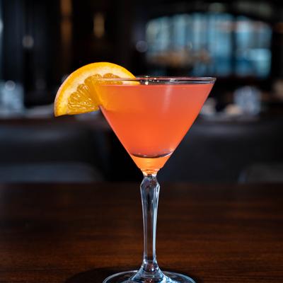 Cosmpolitan cocktail with orange garnish.