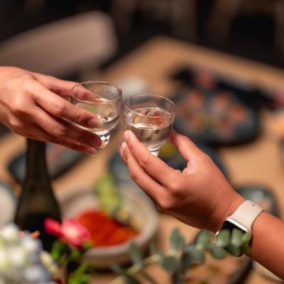 Two people toasting with sake.