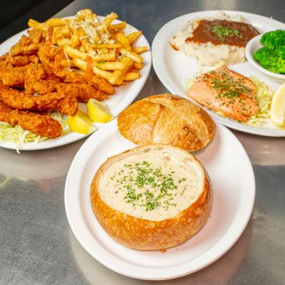 Seafood platter served with fries, soup, vegetables.