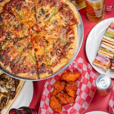 Whole pizza served alongside Club sandwich and portion of wings.