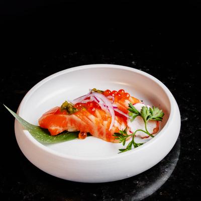 Salmon nigiri topped with salmon roe and garnishes.