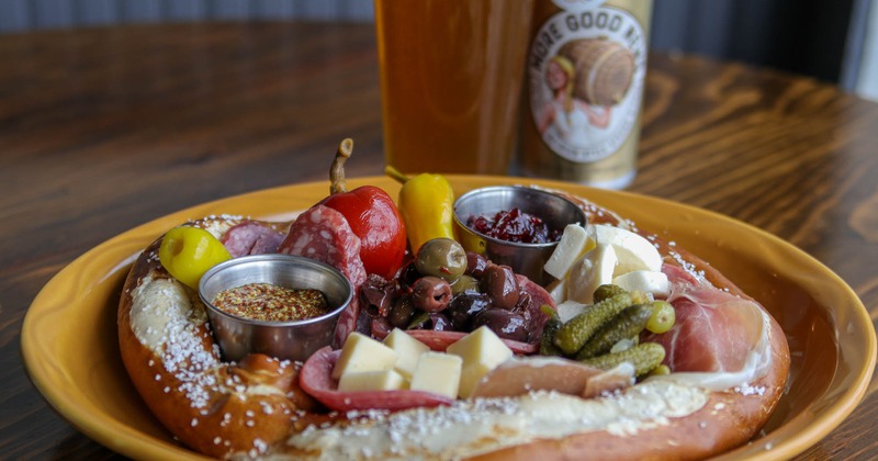 Baked Pretzel with sliced cured meat, pickles, cheese, and jam,served with beer